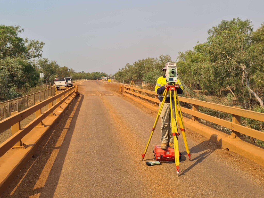 Surveyor using equipment on a roadway