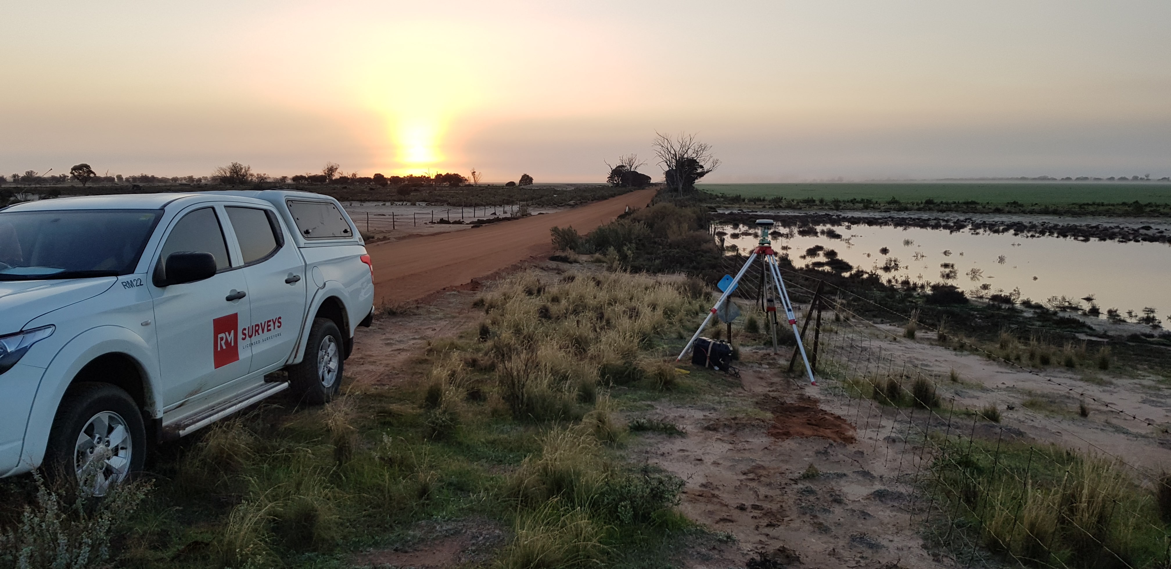 RM Surveys vehicle parked by the beach during sunset